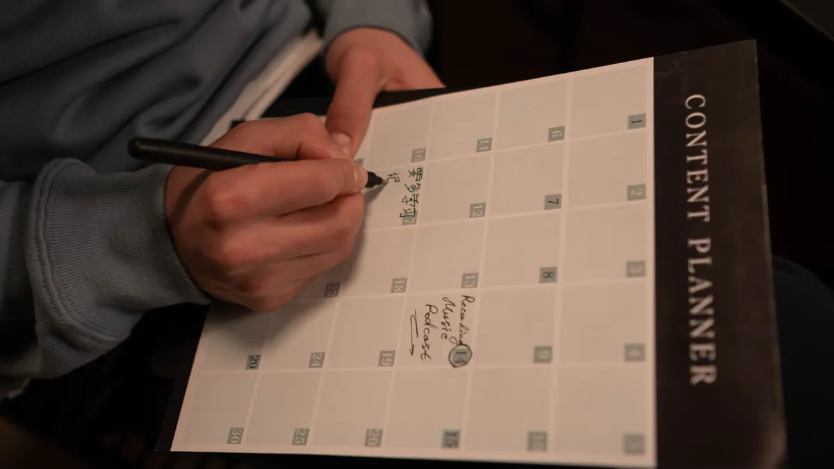 How tronicreview.com chooses what to publish Hand writing in a content planner calendar